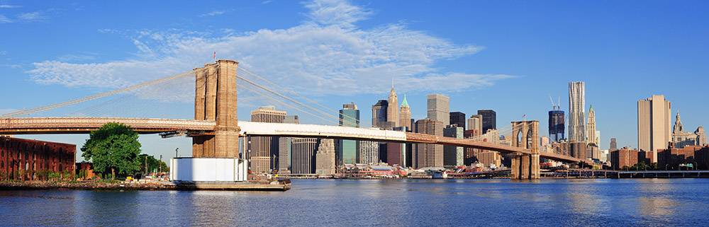 Brooklyn Bridge with lower Manhattan skyline panorama in the morning with cloud and blue sky over East River in New York City